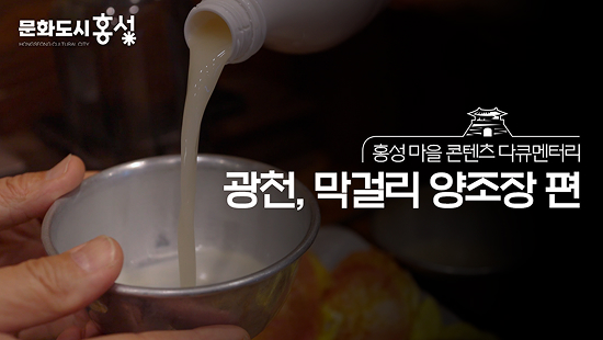 방송 화면의 캡처 이미지로, 막걸리를 따르는 모습 위로 ‘문화도시 홍성’, ‘홍성 마을 콘텐츠 다큐멘터리 광천, 막걸리 양조장 편’이라는 자막이 적힘