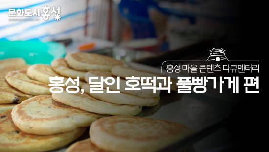 방송 화면의 캡처 이미지로, 수원통일농기구주식회사의 간판 위로 ‘문화도시 홍성’, ‘홍성 마을 콘텐츠 다큐멘터리 광천, 목주와 대풍상회 편’이라는 자막이 적힘
